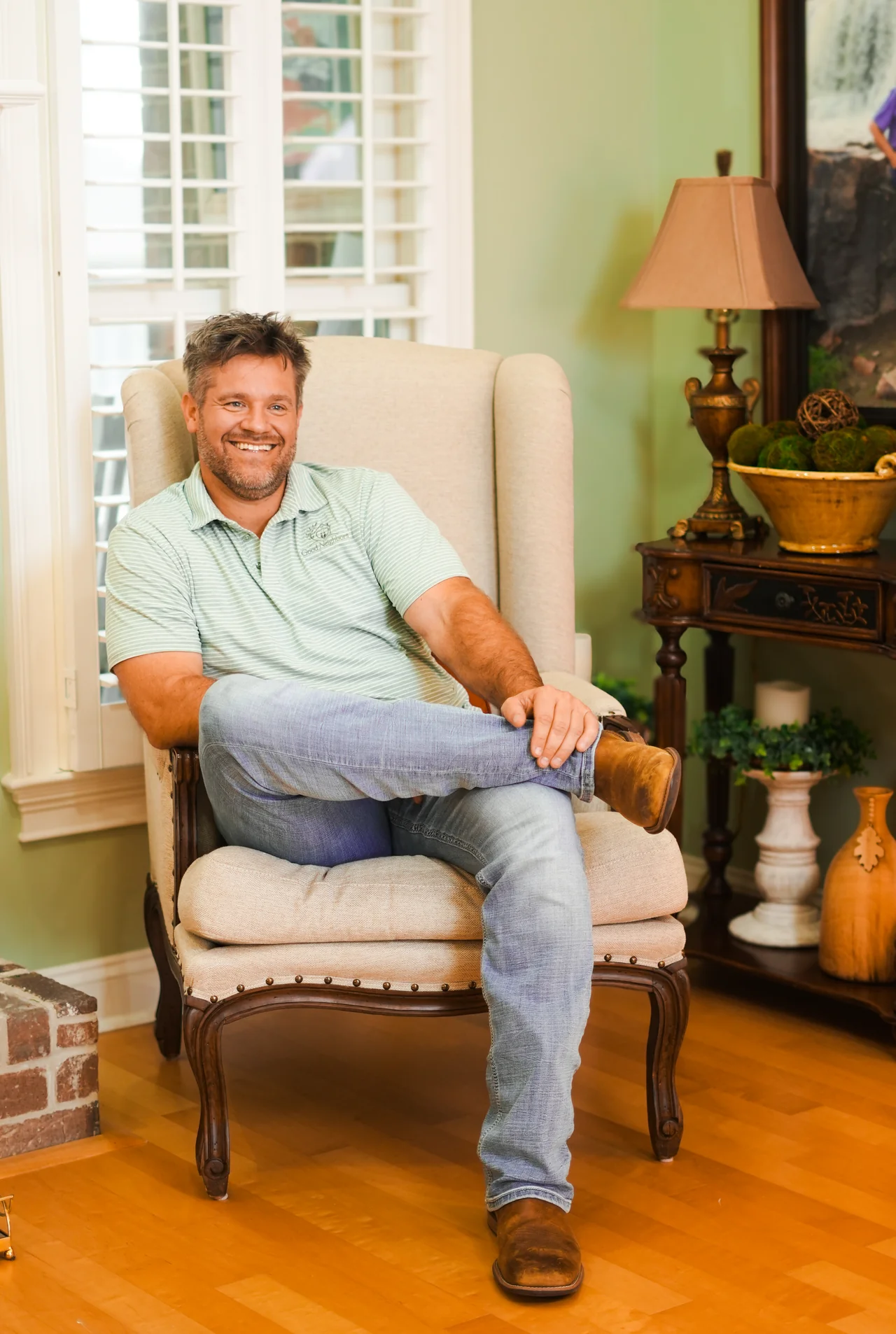 A smiling man seated in an armchair.